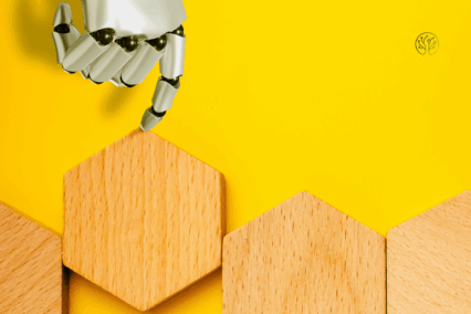 Eine Roboterhand, die einen Holzwürfel in die richtige Reihe schiebt.